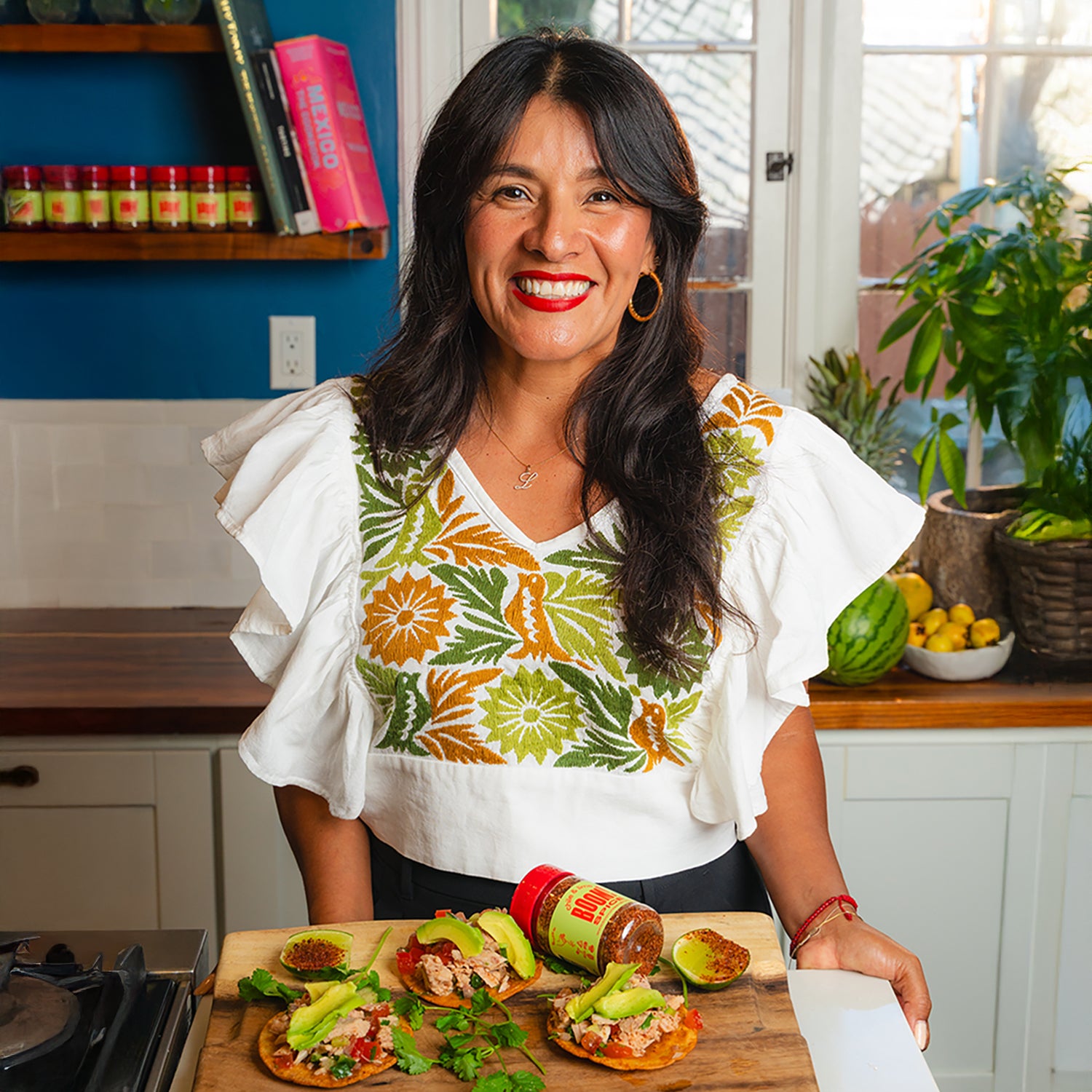 Woman in a kitchen with food on a cutting board