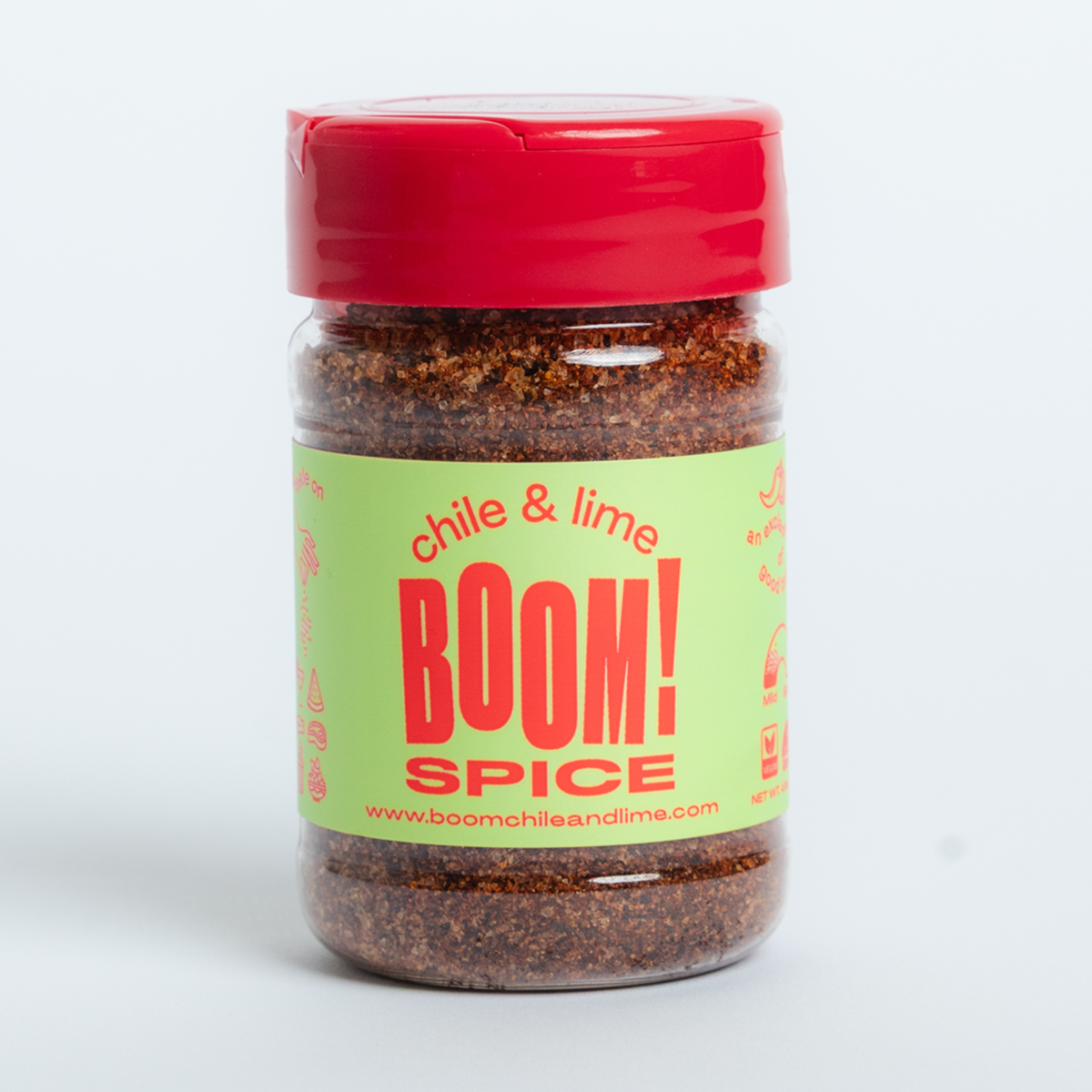 Jar of 'chile & lime BOOM! SPICE' with a red lid and green label on a white background