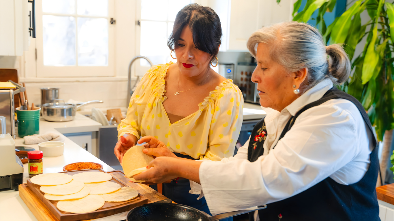 Two women in a kitchen preparing food together.
