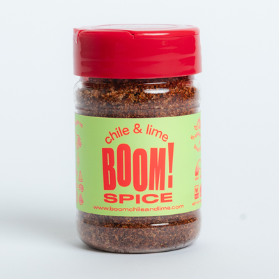 Jar of 'chile & lime BOOM! SPICE' with a red lid and green label on a white background
