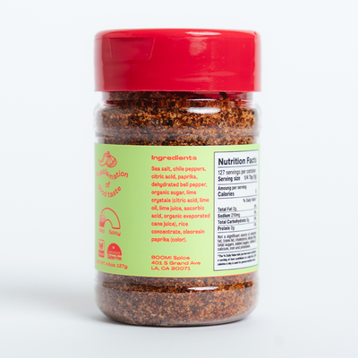 Spice jar with red lid and green label on a white background